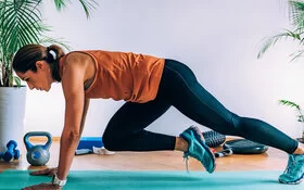 Eine Frau macht Zuhause die Übung Mountain Climber – so gelingt das Cardio Training.