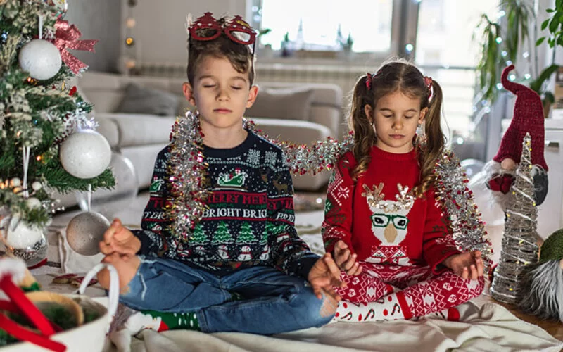 Zwei Kinder genießen ein erholsames Weihnachten vor dem Weihnachtsbaum.