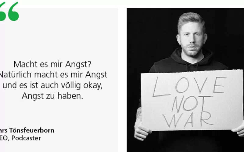 Lars Tönsfeuerborn hält ein Schild in den Händen mit der Aufschrift „Love not war“.