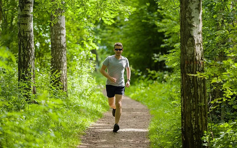 Mann beim Trailrunning im Wald