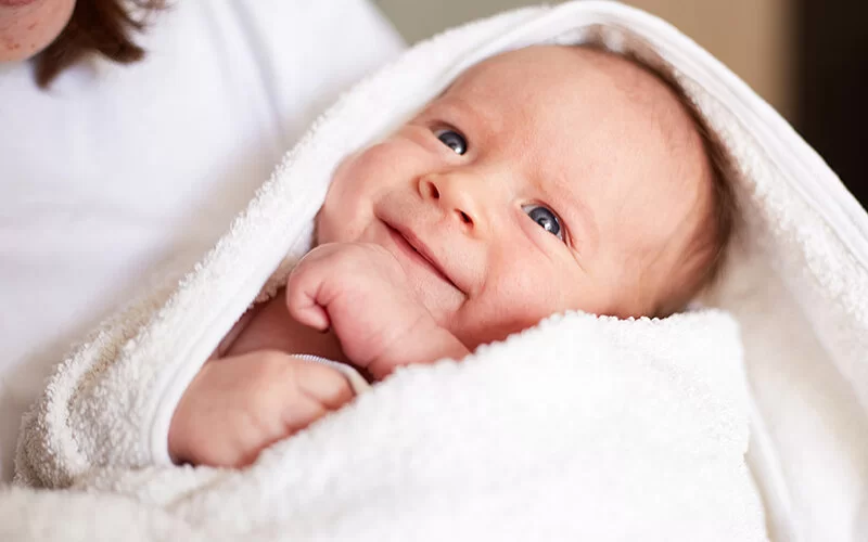 Ein Baby ist in ein weißes Handtuch eingehüllt.