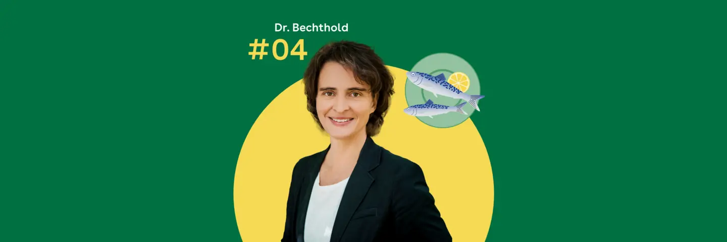 Dr. Angela Bechthold steht vor einem grünen Hintergrund. Rechts daneben ist ein blaugrüner Servierteller mit zwei Fischen zu sehen.