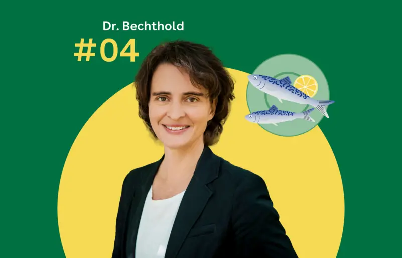 Dr. Angela Bechthold steht vor einem grünen Hintergrund. Rechts daneben ist ein blaugrüner Servierteller mit zwei Fischen zu sehen.