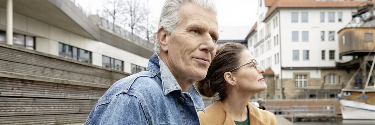 Mann und Frau sitzen am Hafen an der frischen Luft und genießen die Zeit zusammen, die sie noch haben.