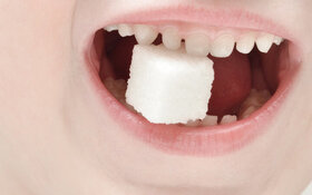 Kleiner Junge mit Würfelzucker im Mund - wieviel Zucker am Tag ist ok?