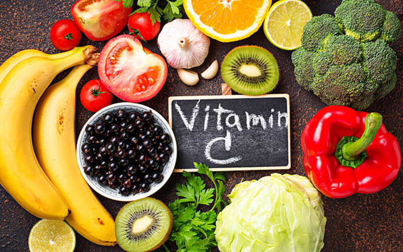 Vitamin-C-haltige Lebensmittel liegen verstreut auf dem Tisch. Sie helfen bei Eisenmangel.