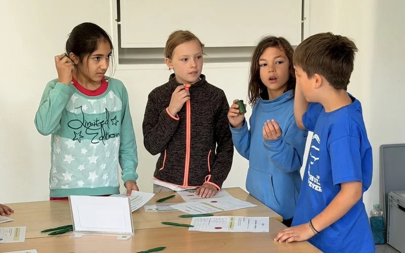 Kinder arbeiten gemeinsam an einer Lernstation und entdecken spielerisch Gesundheits- und Sinnesübungen im Schulprojekt Ahorn@school.