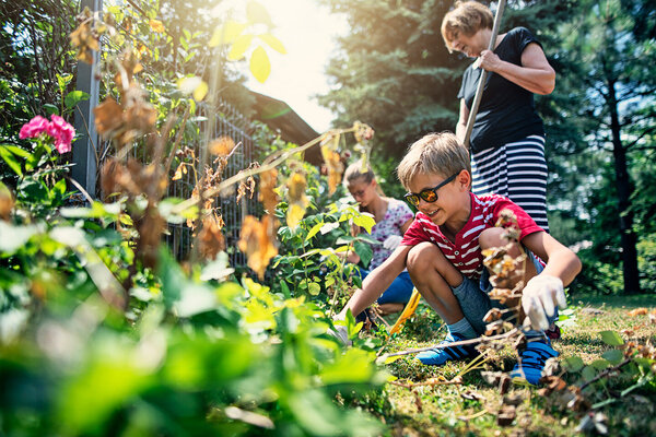 : Kinder helfen bei der Gartenarbeit und lernen dabei etwas über giftige Pflanzen.