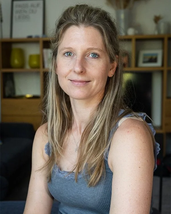 Porträt von Laura Fröhlich, Autorin und Expertin für Mental Load, in ihrem Wohnzimmer.