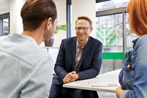 Eine jüngere Frau und ein jüngerer Mann sprechen mit einem AOK-Mitarbeiter. Persönliche Beratung ist der AOK sehr wichtig.