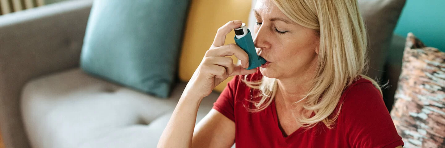 Eine Frau mit Asthma benutzt einen Asthmainhalator.