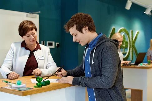 Ein junger Mann lässt sich von einer Mitarbeiterin der AOK beim Ausfüllen einer Vollmacht beraten. Schon in jungen Jahren sollten die wichtigsten Entscheidungen für den Notfall geklärt sein.