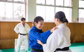 Ein Mädchen packt ein anderes Mädchen am Kragen, sie tragen beide einen Judo-Anzug. Versicherte der AOK Bremen/Bremerhaven haben Vorteile beim OSC Bremerhaven.