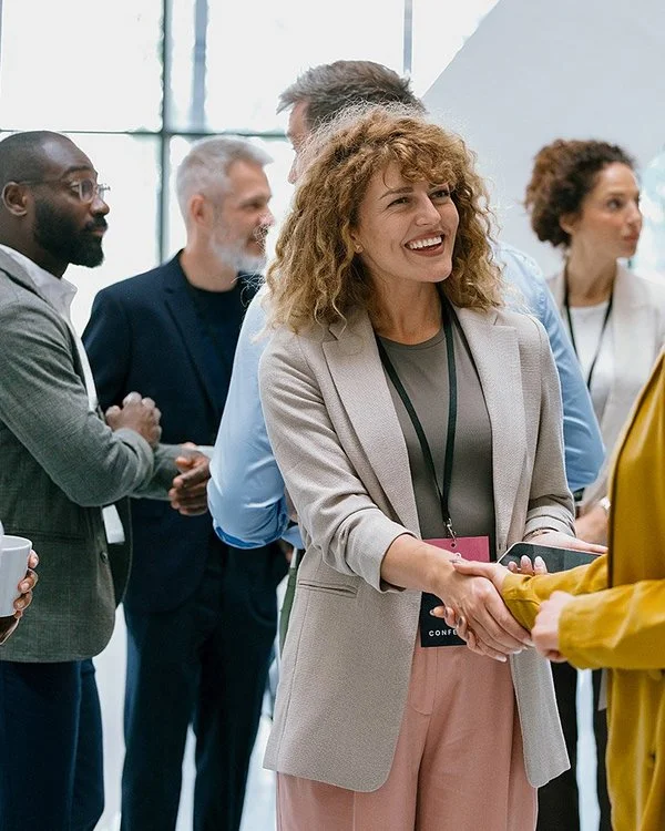 Eine Gruppe Menschen begrüßt sich im Vorraum vor dem Konferenzsaal