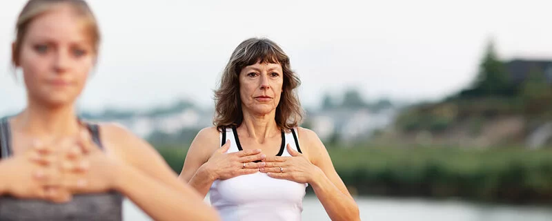 Zwei Frauen praktizieren Atem- und Körperübungen, die bei der Rauchentwöhnung helfen können.