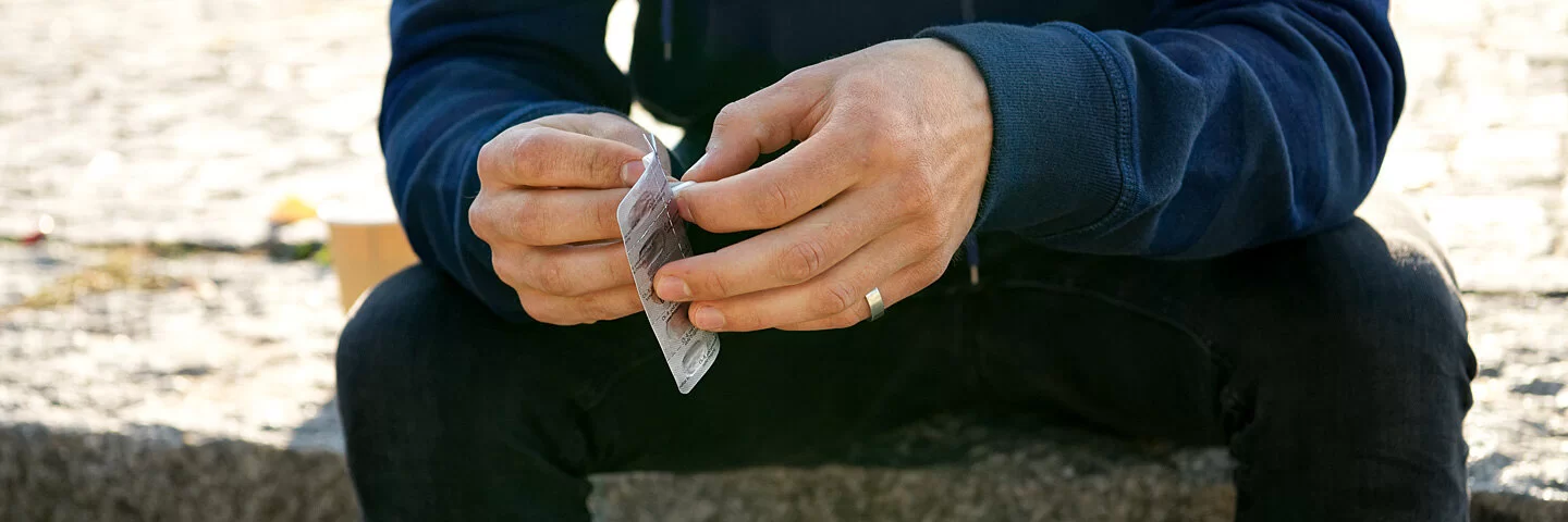 Ein Mann hält einen Blister mit Tabletten in der Hand. Wie Patienten Medikamente richtig einnehmen, erfahren Sie im Beitrag.