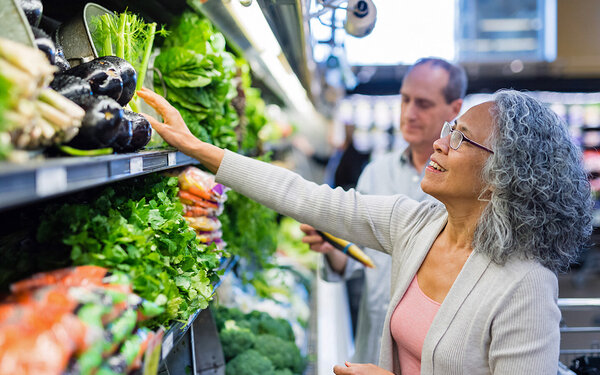 Älteres Ehepaar kauft gemeinsam frisches Gemüse in einem Supermarkt.