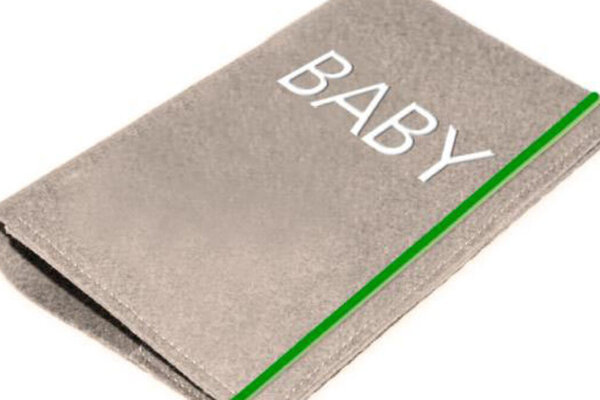 Man sieht eine beige Passhülle mit der Aufschrift: "Baby".