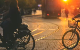 Personen fahren mit Fahrrädern in der Abenddämmerung in der Stadt.