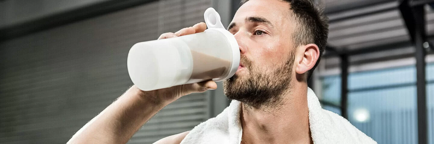 Sportmythen: Mann trinkt für den Muskelaufbau einen Proteinshake nach dem Training.