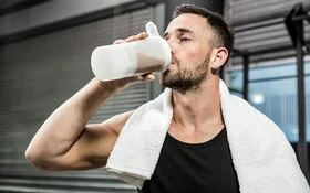 Sportmythen: Mann trinkt für den Muskelaufbau einen Proteinshake nach dem Training.