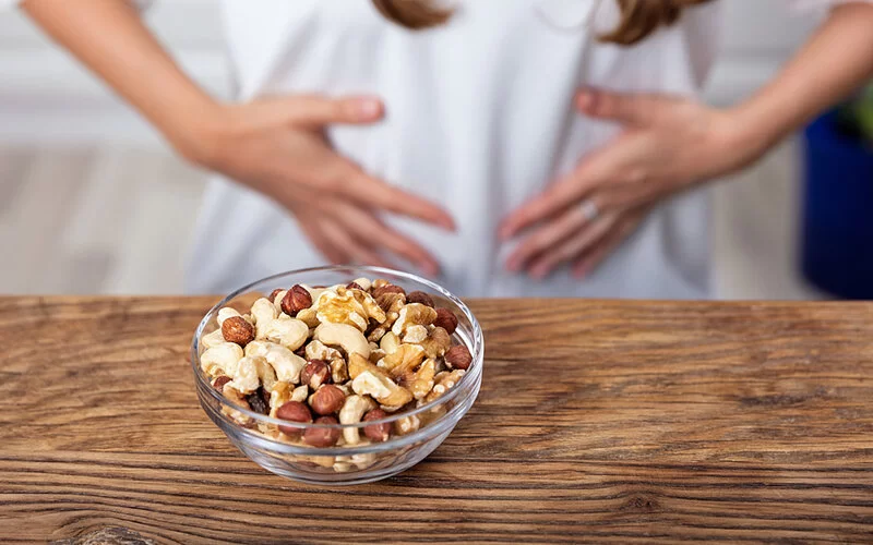 Frau mit Kreuzallergie kann keine Nüsse essen.