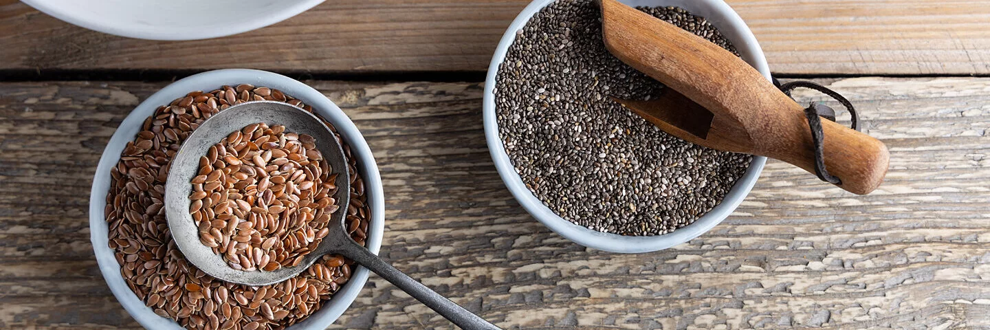 Chia- und Leinsamen in Schalen auf einem Tisch.