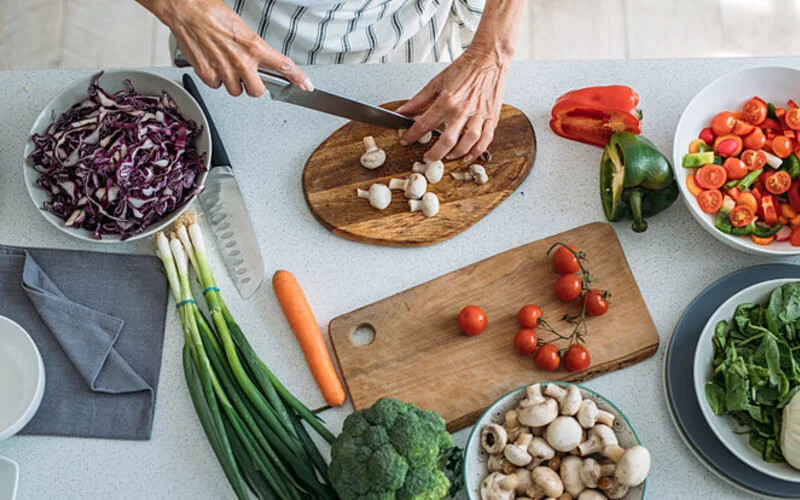 Frau bereitet blutdrucksenkende Lebensmittel vor, um sich gesund zu ernähren.