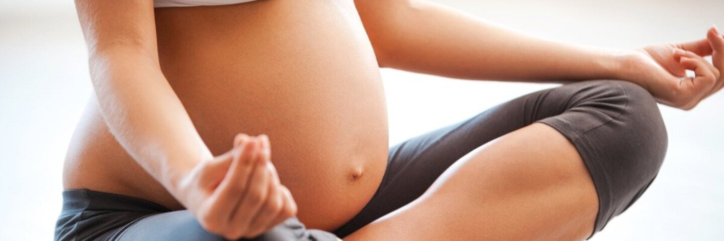 Eine schwangere Frau macht Yoga