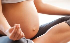 Eine schwangere Frau macht Yoga