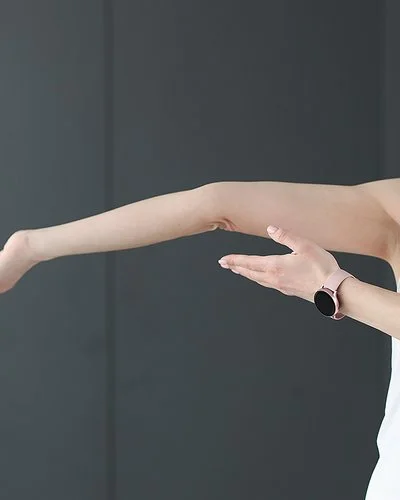 Eine junge Frau zeigt auf ihren überstreckten Arm.