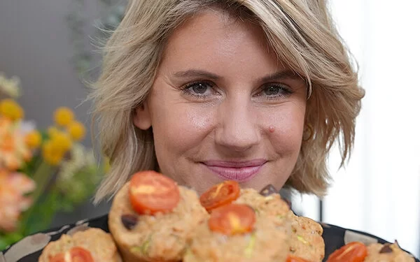 TV-Köchin Felicitas Then hält einen Teller mit Gemüsemuffins in die Kamera.
