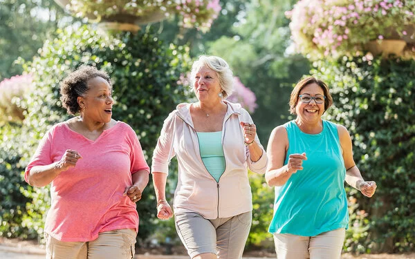 Drei Seniorinnen haben Spaß beim gemeinsamen Joggen.