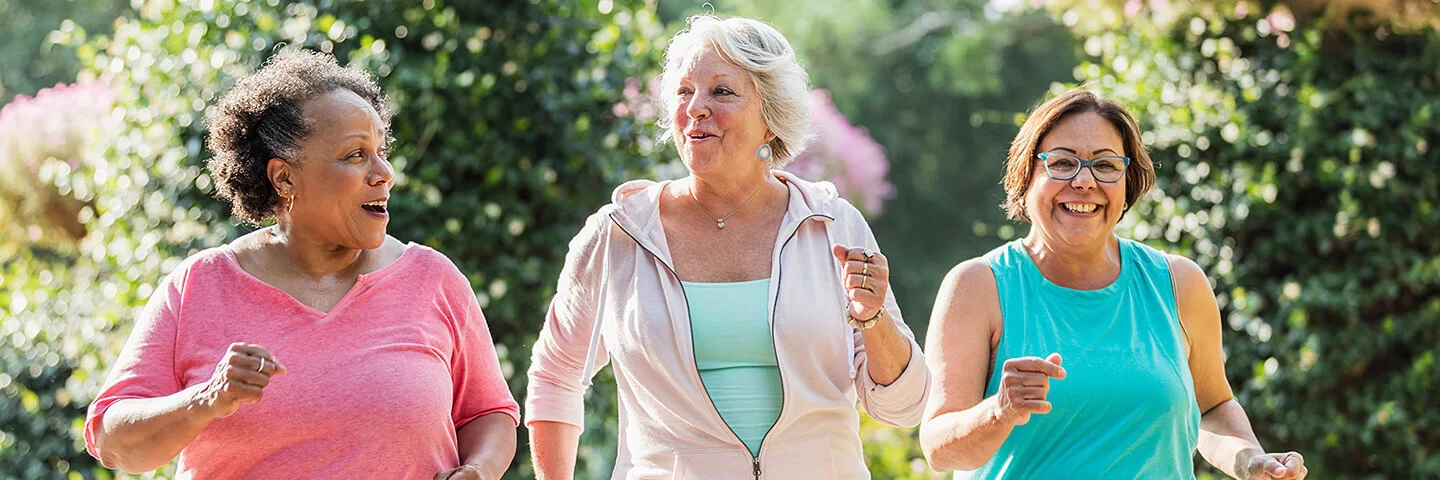 Drei Seniorinnen haben Spaß beim gemeinsamen Joggen.