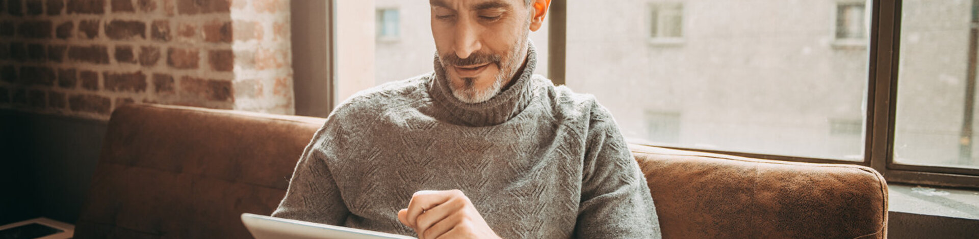 Ein älterer Mann liest etwas auf seinem Tablet. Hat er den AOK-Newsletter abonniert, kann er sich jederzeit abmelden.