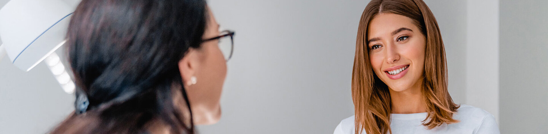 Eine Frauenärztin spricht mit einer jungen Patientin. Die Früherkennung von Gebärmutterhalskrebs betrifft alle Frauen.