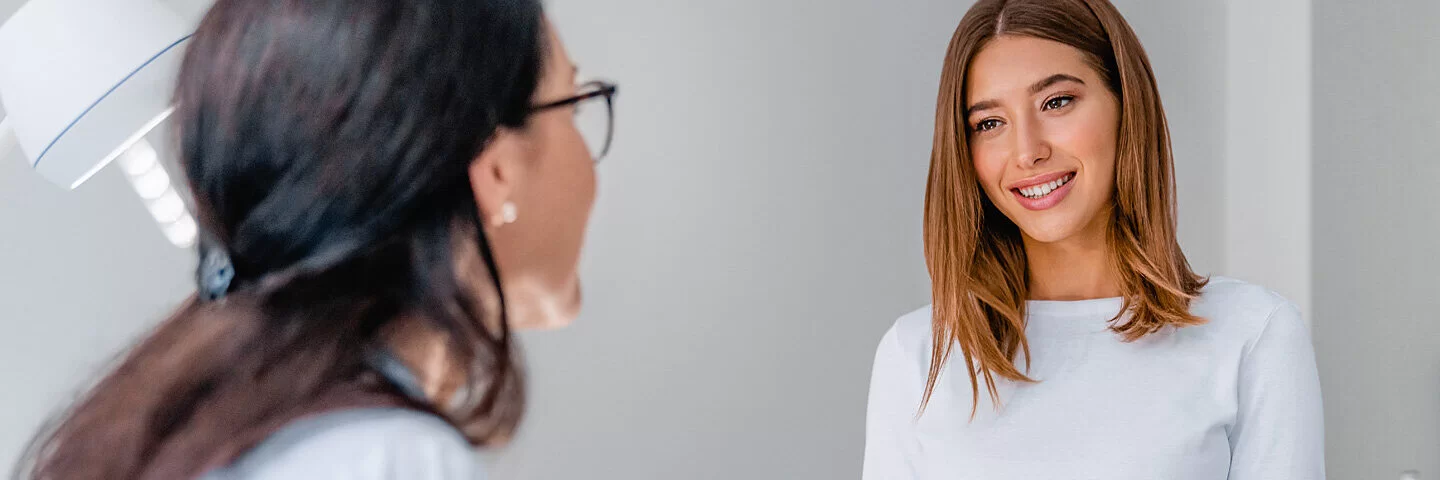Eine Frauenärztin spricht mit einer jungen Patientin. Die Früherkennung von Gebärmutterhalskrebs betrifft alle Frauen.