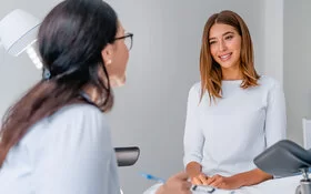 Eine Frauenärztin spricht mit einer jungen Patientin. Die Früherkennung von Gebärmutterhalskrebs betrifft alle Frauen.