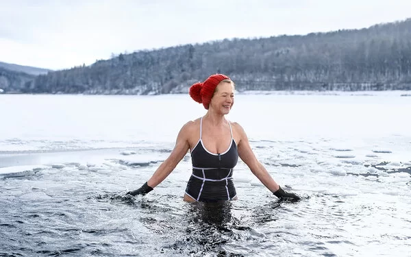 Frau mit Mütze geht Eisbaden.