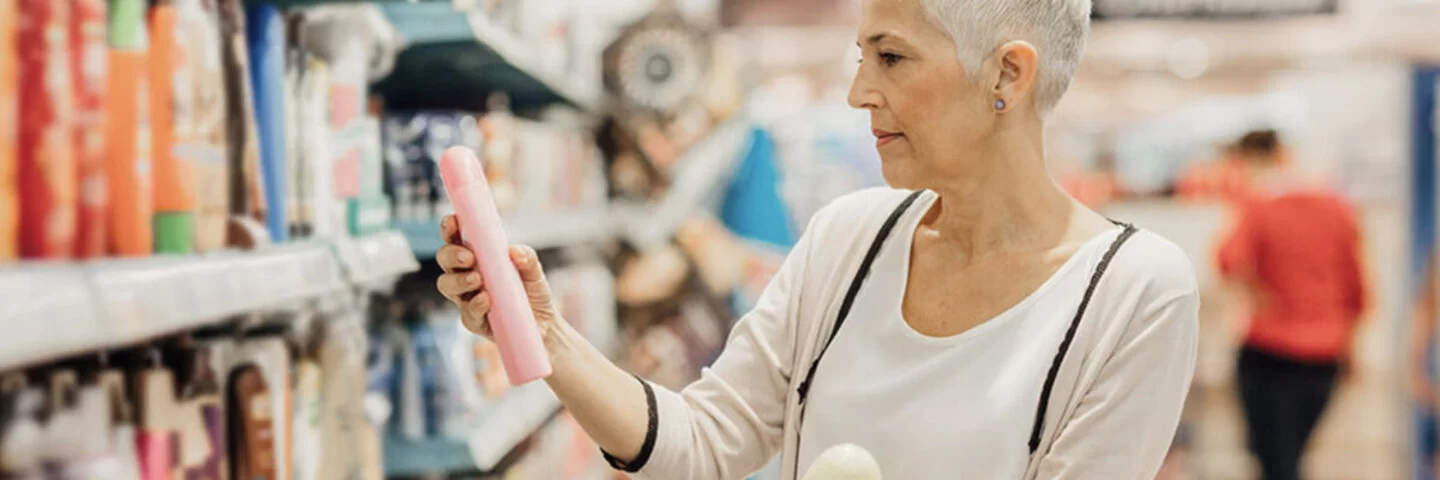Frau achtet beim Kauf von Duschgel auf Mikroplastik