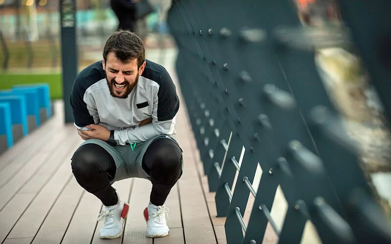 Sportlicher Mann hat beim Joggen falsch geatmet und nun Seitenstechen.