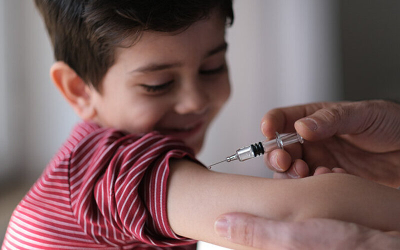 Ein Junge streckt den Arm aus, um eine Impfung gegen Masern zu bekommen.