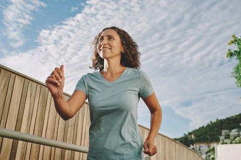 Frau im mittleren Alter beim Walking im Freien.