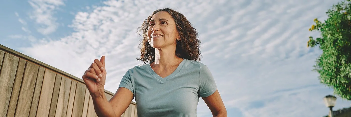 Frau im mittleren Alter beim Walking im Freien.