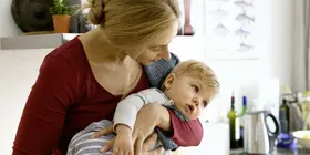 Eine Frau hält ihr Kleinkind, das sich verschluckt hat.