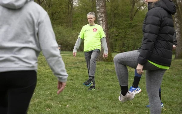 Ein Sportler in grünem Trikot beim Aufwärmen.