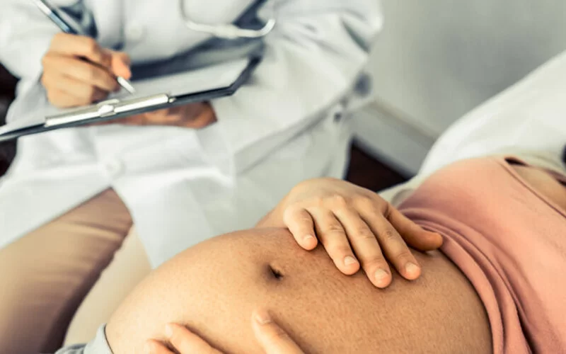 Eine schwangere Frau bei der Besprechung mit Ihrem Arzt.