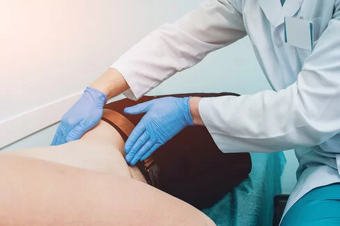 Bei einer Prostata-Vorsorgeuntersuchung tastet ein Urologe den Bauchraum eines Patienten ab.