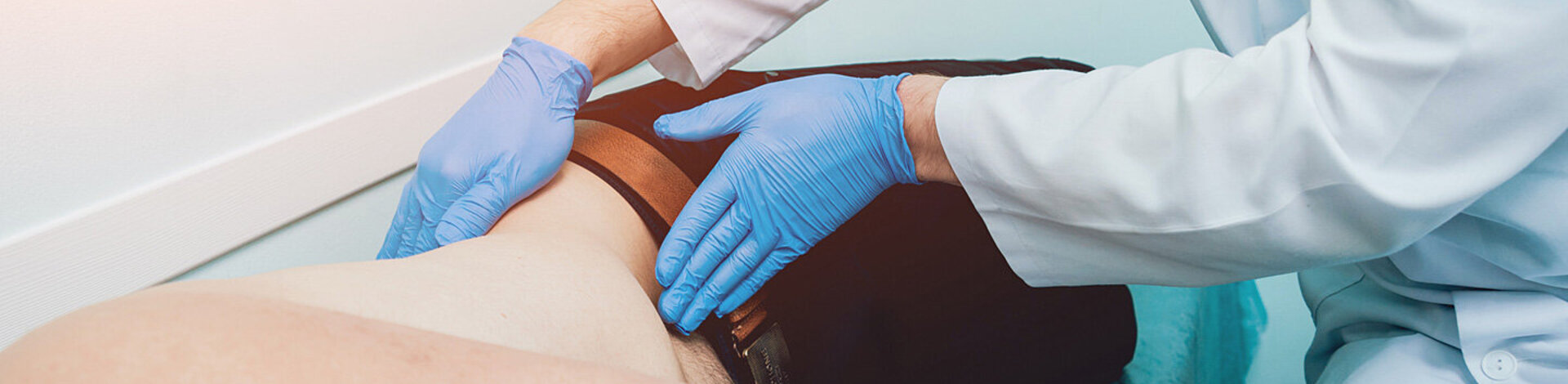 Bei einer Prostata-Vorsorgeuntersuchung tastet ein Urologe den Bauchraum eines Patienten ab.