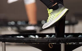 Zwei Menschen machen Jumping Fitness auf zwei Mini-Trampolins.